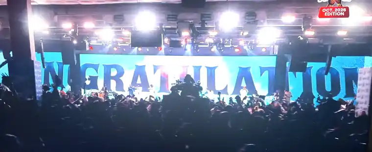 Crowd with hands raised in front of the Hallelujah Festival stage showing a giant Congratulations screen, October 2026