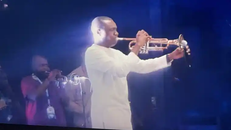 Worship leader in white playing the trumpet on stage at the Hallelujah Festival, October 2026